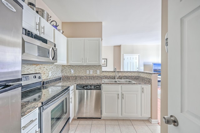 kitchen with white cabinets, sink, light tile patterned floors, and stainless steel appliances