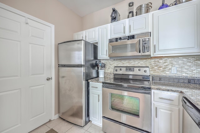 kitchen with stainless steel appliances, light tile patterned floors, tasteful backsplash, stone countertops, and white cabinets