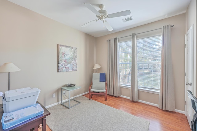 living area featuring hardwood / wood-style floors, ceiling fan, and a healthy amount of sunlight