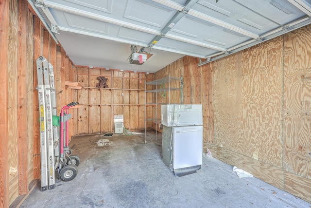 garage with wooden walls, a garage door opener, and fridge