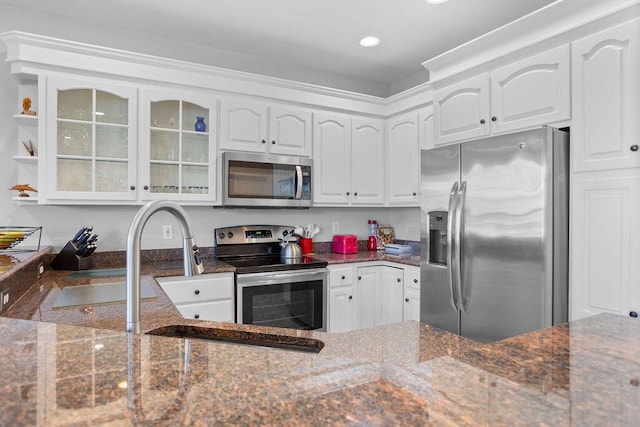 kitchen featuring dark stone countertops, sink, white cabinets, and stainless steel appliances