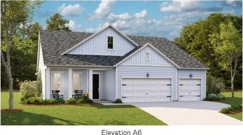 view of front of property with board and batten siding, a front lawn, a garage, and driveway