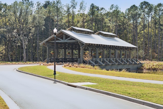 view of community featuring a forest view and a yard