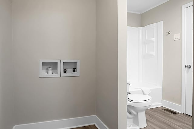 bathroom featuring toilet, tub / shower combination, and wood-type flooring