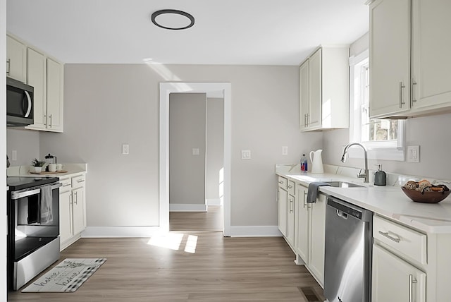 kitchen featuring light stone countertops, sink, white cabinetry, and appliances with stainless steel finishes