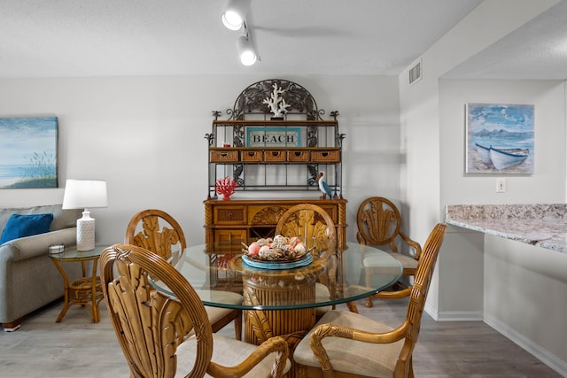 dining space featuring visible vents, baseboards, and wood finished floors