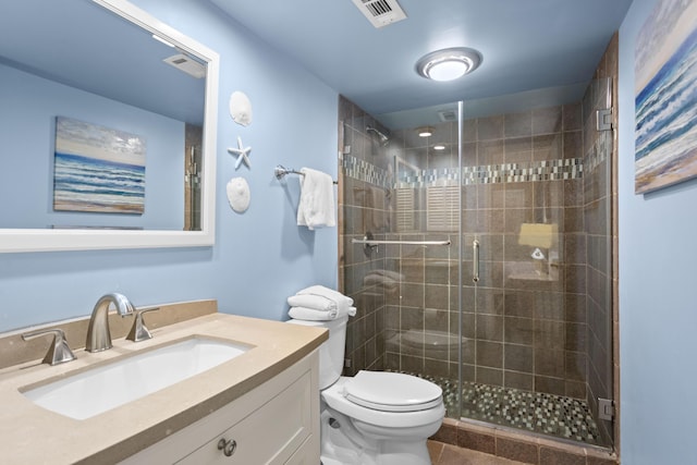 bathroom featuring visible vents, a shower stall, toilet, and vanity