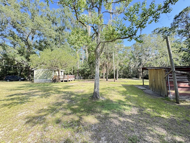 4589 Prices Bridge Ln, Walterboro, SC 29488 - view of grassy yard with a deck, an outdoor structure, and view of scattered trees