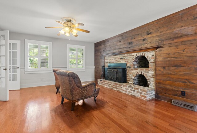 206 Chaussee Blvd, Summerville, SC 29483 - living room featuring ceiling fan, a fireplace, wood finished floors, baseboards, and wooden walls