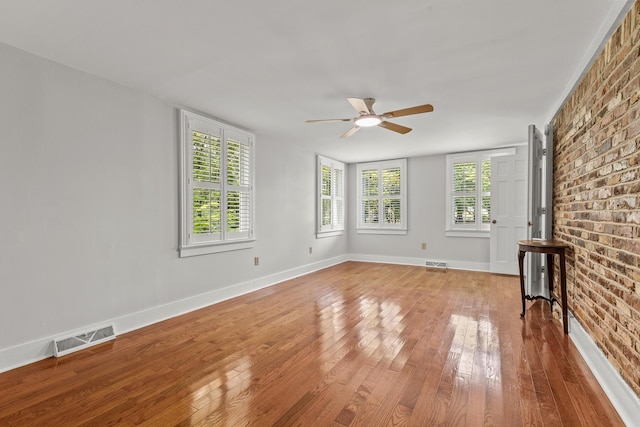 206 Chaussee Blvd, Summerville, SC 29483 - unfurnished living room with wood-type flooring, ceiling fan, brick wall, and baseboards