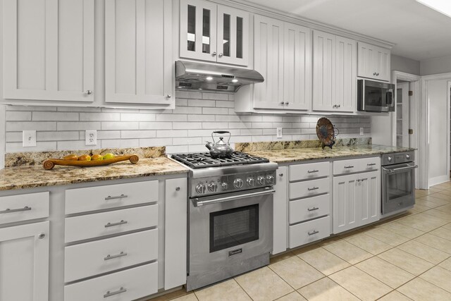 206 Chaussee Blvd, Summerville, SC 29483 - kitchen with stainless steel appliances, under cabinet range hood, decorative backsplash, light tile patterned flooring, and light stone counters