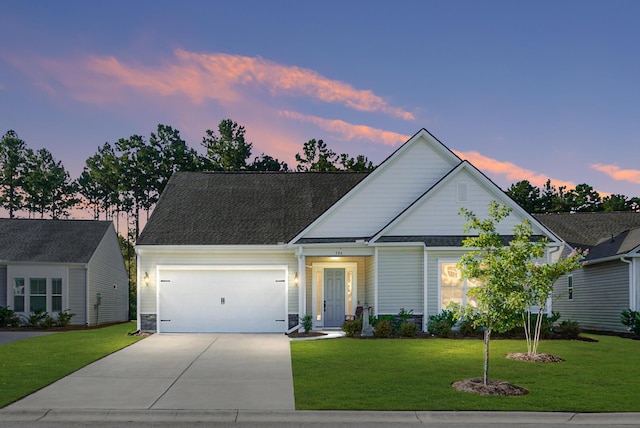 traditional-style home featuring driveway, an attached garage, a shingled roof, and a front yard