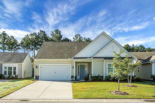 traditional home with a garage, driveway, a front lawn, and roof with shingles