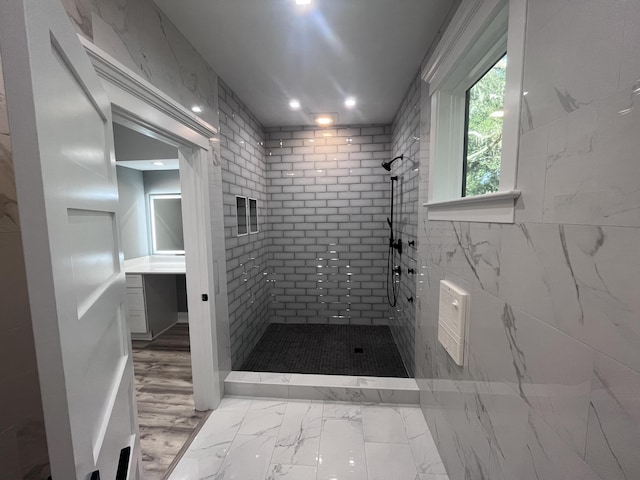 bathroom featuring a tile shower and tile walls