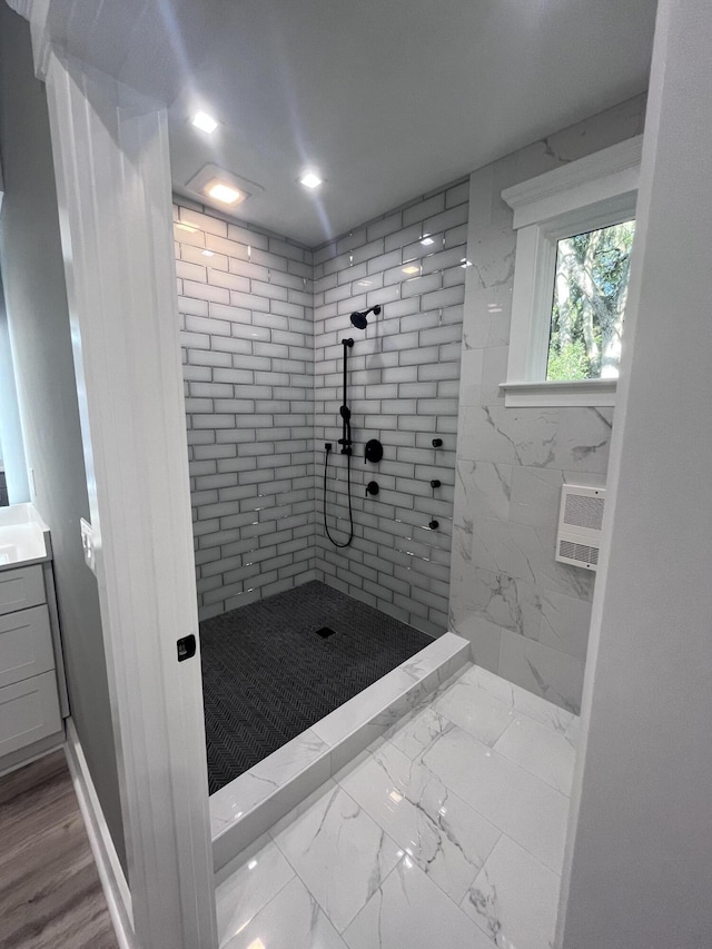 bathroom featuring tiled shower and vanity