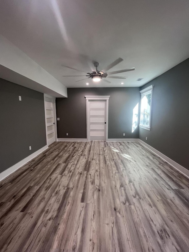 interior space featuring hardwood / wood-style flooring, ceiling fan, and built in shelves