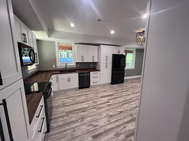 kitchen featuring white cabinetry, plenty of natural light, sink, and black appliances