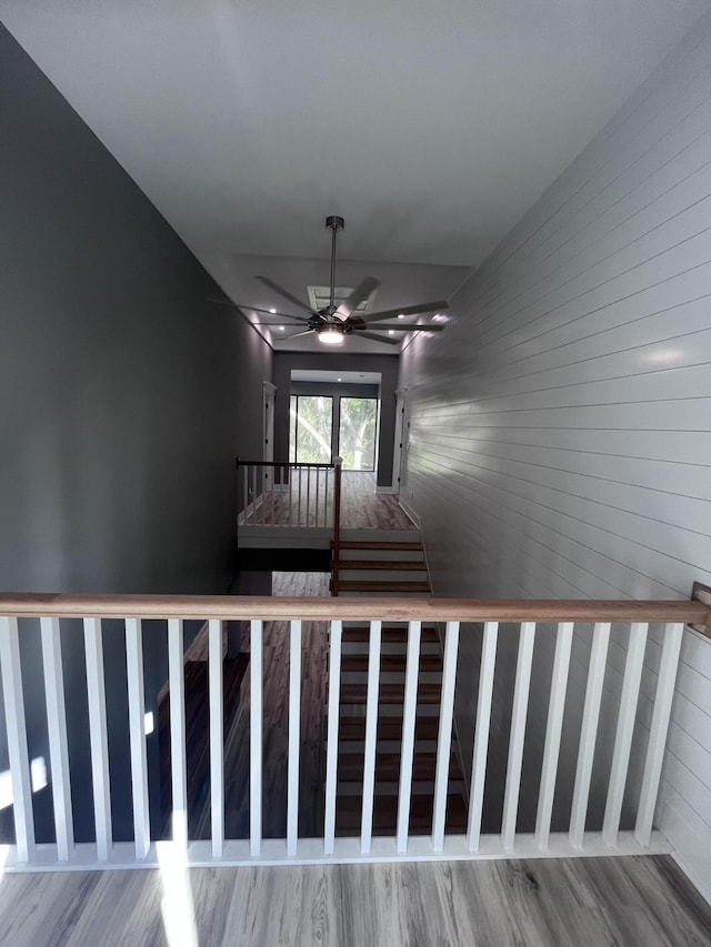 stairway with hardwood / wood-style flooring and ceiling fan