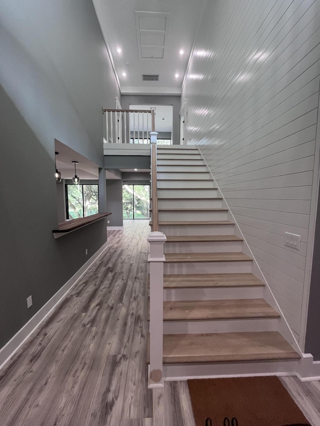 staircase featuring hardwood / wood-style floors and a towering ceiling