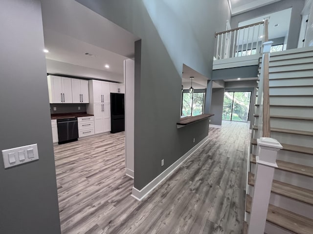 interior space featuring wood-type flooring and a towering ceiling