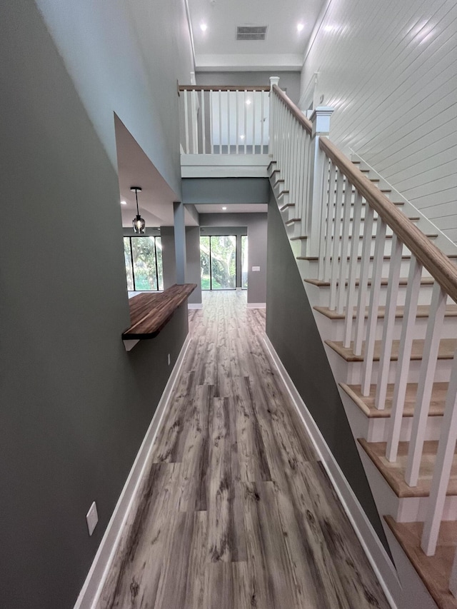 stairway with hardwood / wood-style flooring and a high ceiling