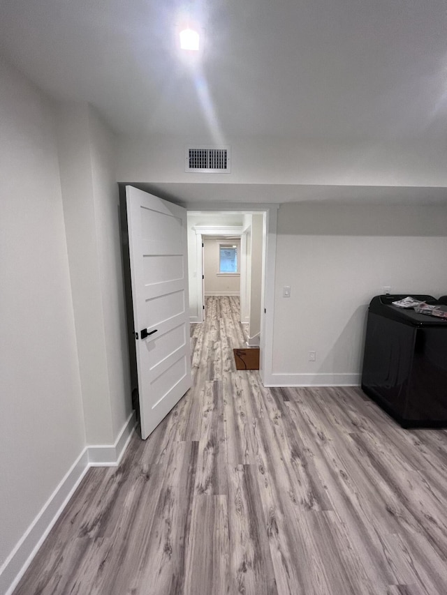 hallway with light hardwood / wood-style floors