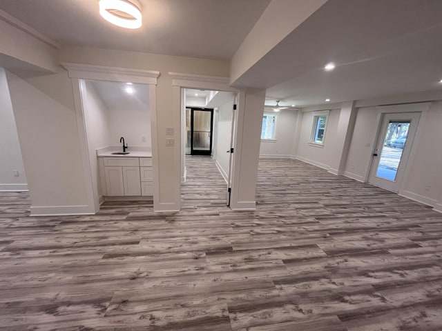 basement featuring sink and light wood-type flooring