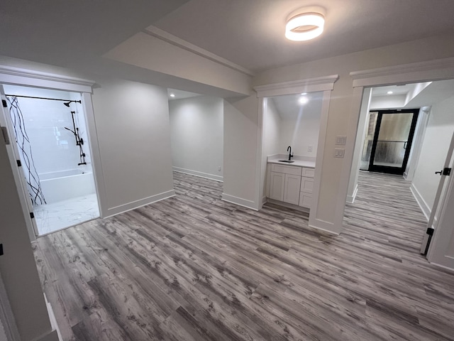 basement with sink and light hardwood / wood-style flooring