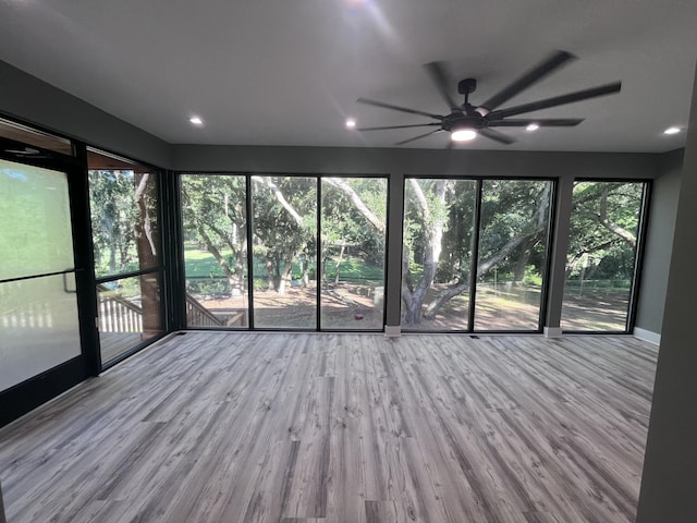 unfurnished sunroom featuring ceiling fan