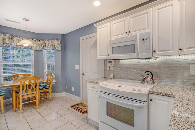 kitchen with white appliances, light stone countertops, decorative light fixtures, light tile patterned floors, and tasteful backsplash