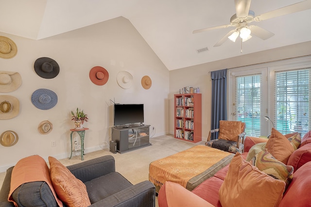 living room featuring ceiling fan, lofted ceiling, light carpet, and a wood stove