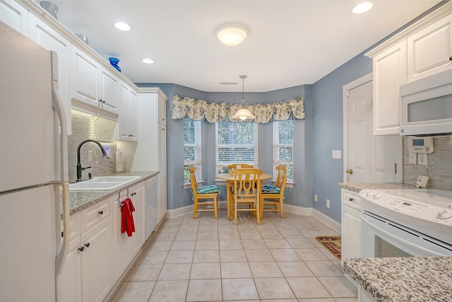 kitchen featuring white appliances, decorative light fixtures, backsplash, white cabinetry, and sink