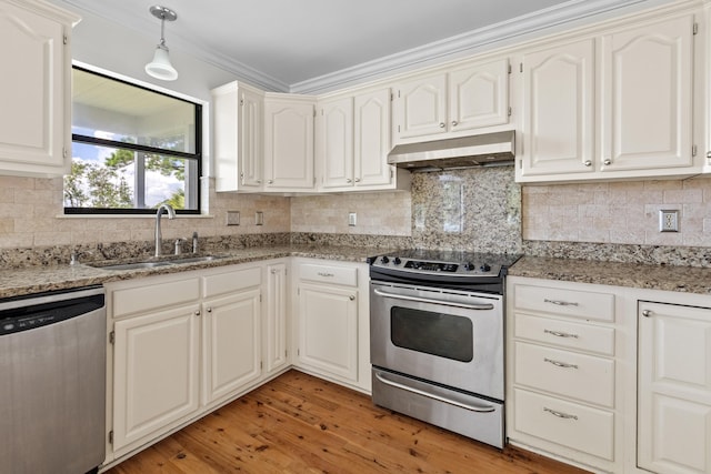 633 Stono Edge Dr, Charleston, SC 29412 - kitchen featuring appliances with stainless steel finishes, under cabinet range hood, ornamental molding, light wood-type flooring, and backsplash