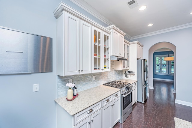 1721 Wellstead St, Mount Pleasant, SC 29466 - kitchen with appliances with stainless steel finishes, arched walkways, under cabinet range hood, backsplash, and glass insert cabinets