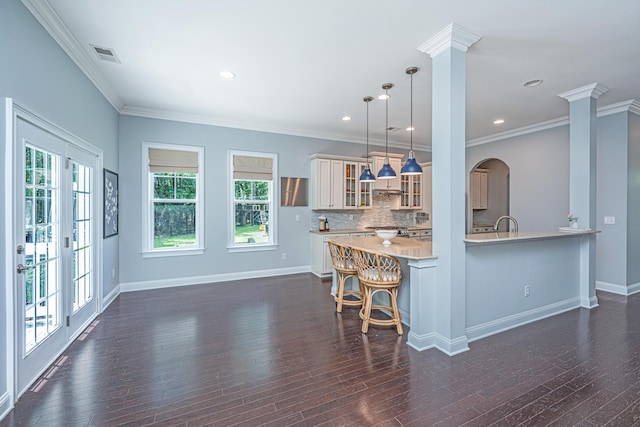1721 Wellstead St, Mount Pleasant, SC 29466 - kitchen featuring light countertops, decorative columns, healthy amount of natural light, glass insert cabinets, and crown molding