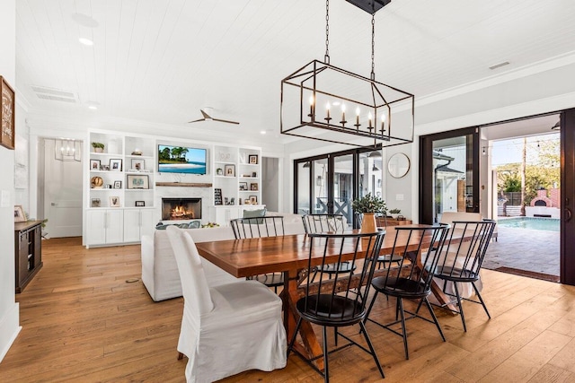 dining space with built in shelves, light hardwood / wood-style floors, crown molding, and wooden ceiling