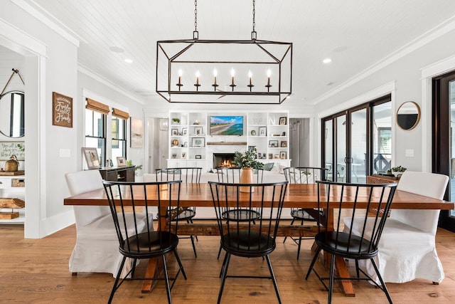 dining area with light wood-type flooring, wood ceiling, crown molding, and plenty of natural light