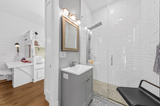 bathroom featuring a shower with door, wood-type flooring, and vanity