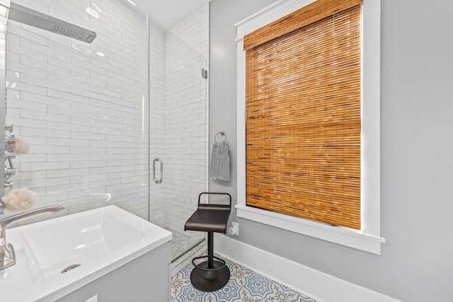 bathroom with walk in shower, sink, and tile patterned flooring