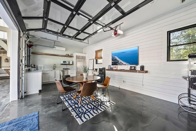 dining room featuring wooden walls and sink