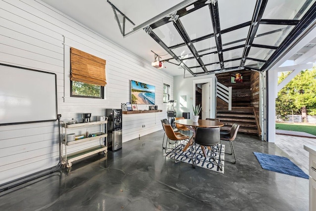 garage featuring a garage door opener and wooden walls