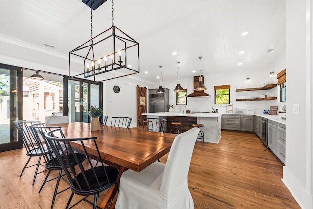 dining space with wine cooler, an inviting chandelier, wood ceiling, light hardwood / wood-style flooring, and crown molding