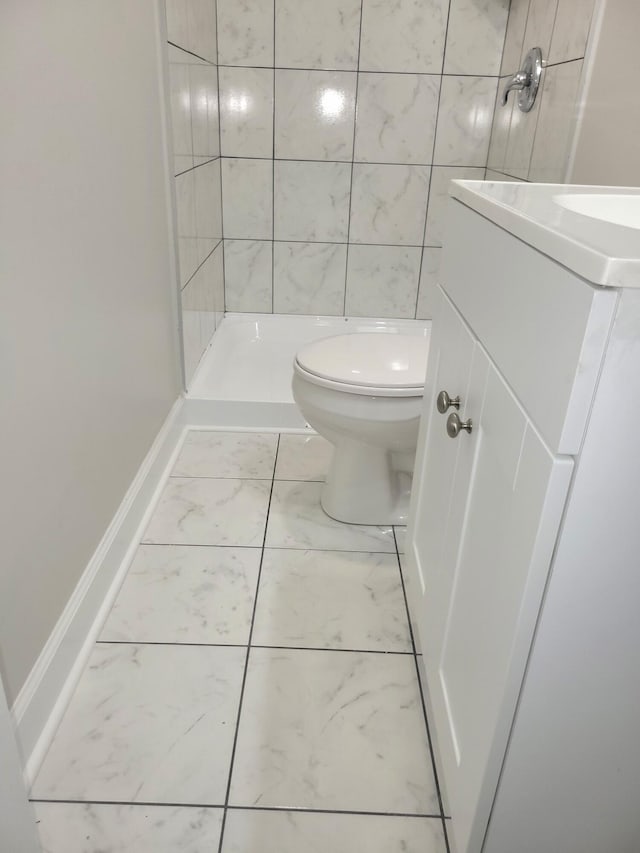 bathroom featuring toilet and a tile shower