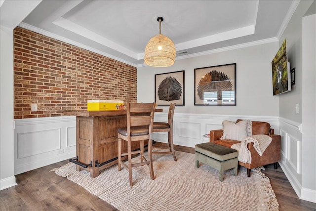 office area featuring a raised ceiling, wainscoting, and wood finished floors