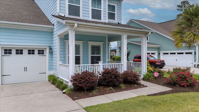 view of front facade featuring a porch, an attached garage, driveway, and a shingled roof