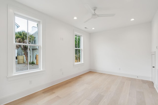 spare room featuring ceiling fan, light hardwood / wood-style flooring, and a healthy amount of sunlight