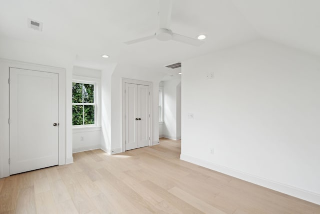 unfurnished bedroom featuring ceiling fan, light wood-type flooring, and vaulted ceiling