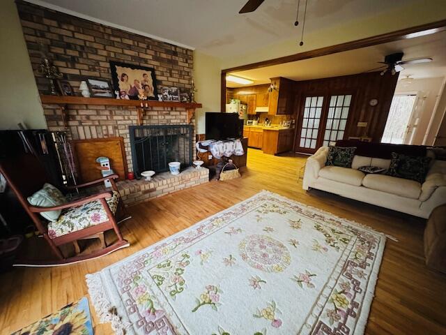 living room with wood-type flooring and a brick fireplace