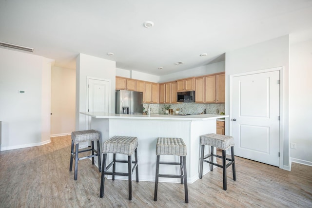 743 Redbud Ln, Summerville, SC 29486 - kitchen featuring stainless steel appliances, light wood-style flooring, light countertops, an island with sink, and a breakfast bar