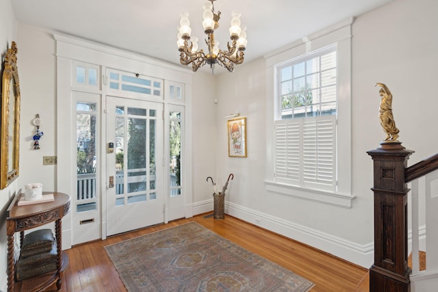 entryway featuring wood-type flooring and a notable chandelier